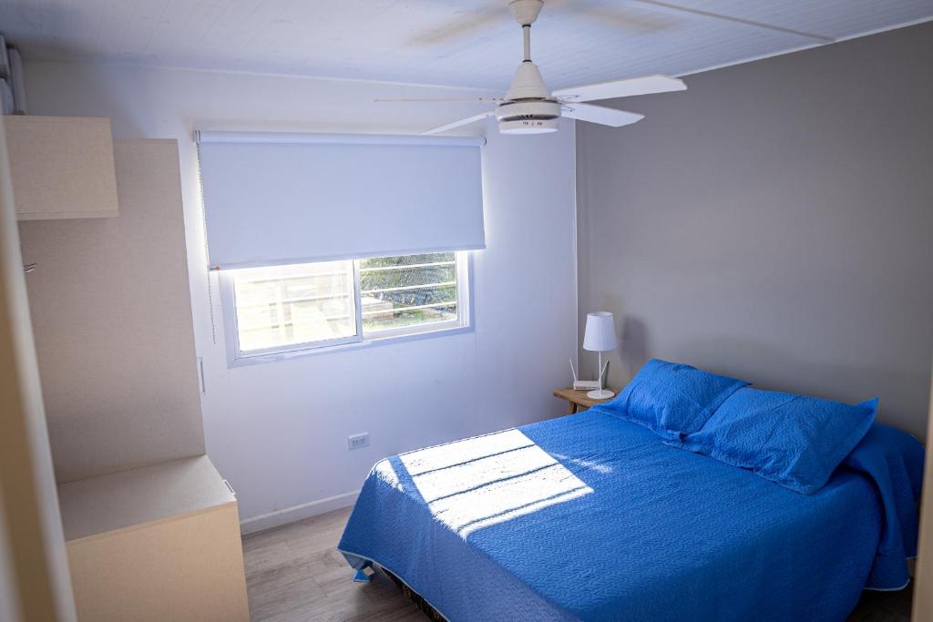 una camera con letto blu e ventilatore a soffitto di Casa quinta Los Teros a Junín