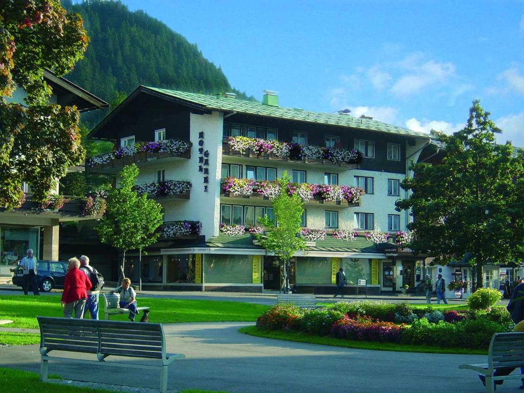 a building with people sitting on a bench in front of it at Hotel-Garni Fels in Riezlern