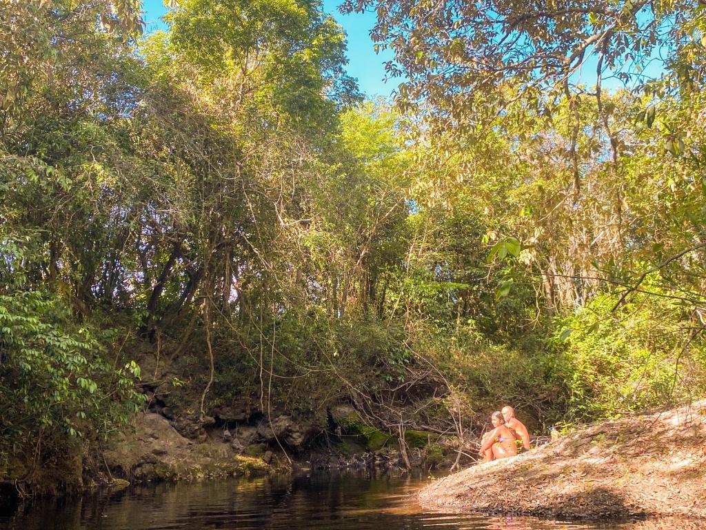 un par de personas en el agua en un río en Alto Paraíso de Goias Camping e Estúdio, en Alto Paraíso de Goiás