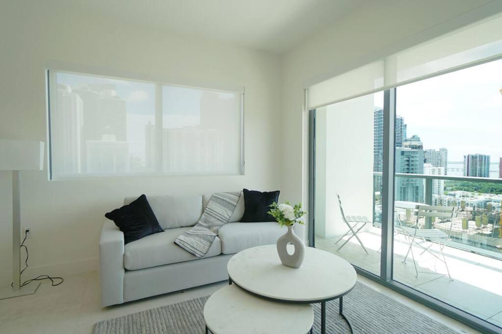 a white living room with a couch and a table at Brand New Apartment in Brickell with parking in Miami
