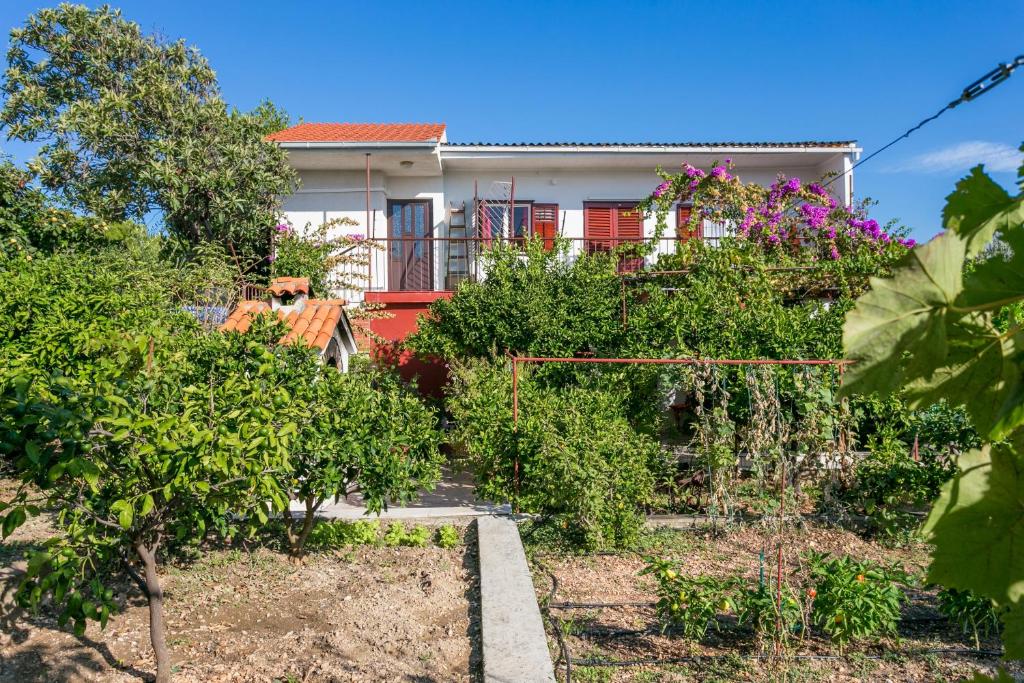 une maison avec un jardin en face dans l'établissement Apartments by the sea Seget Vranjica, Trogir - 1038, à Seget Vranjica