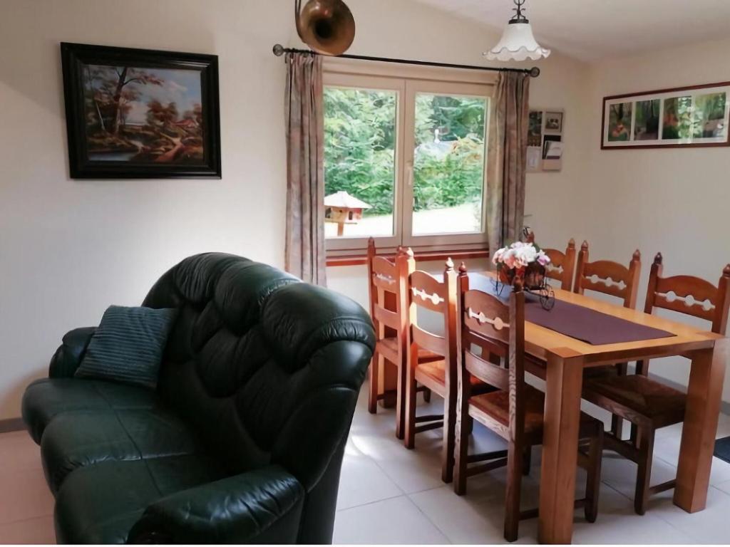 sala de estar con mesa y sofá de cuero en Authentic chalet in Wibrin with private fish pond en Wibrin