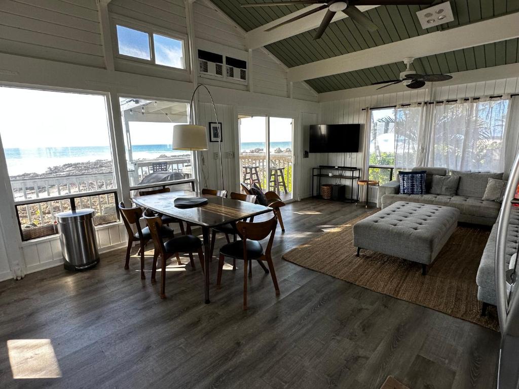 a living room with a table and chairs and a couch at Amazing Ocean View! in Haleiwa