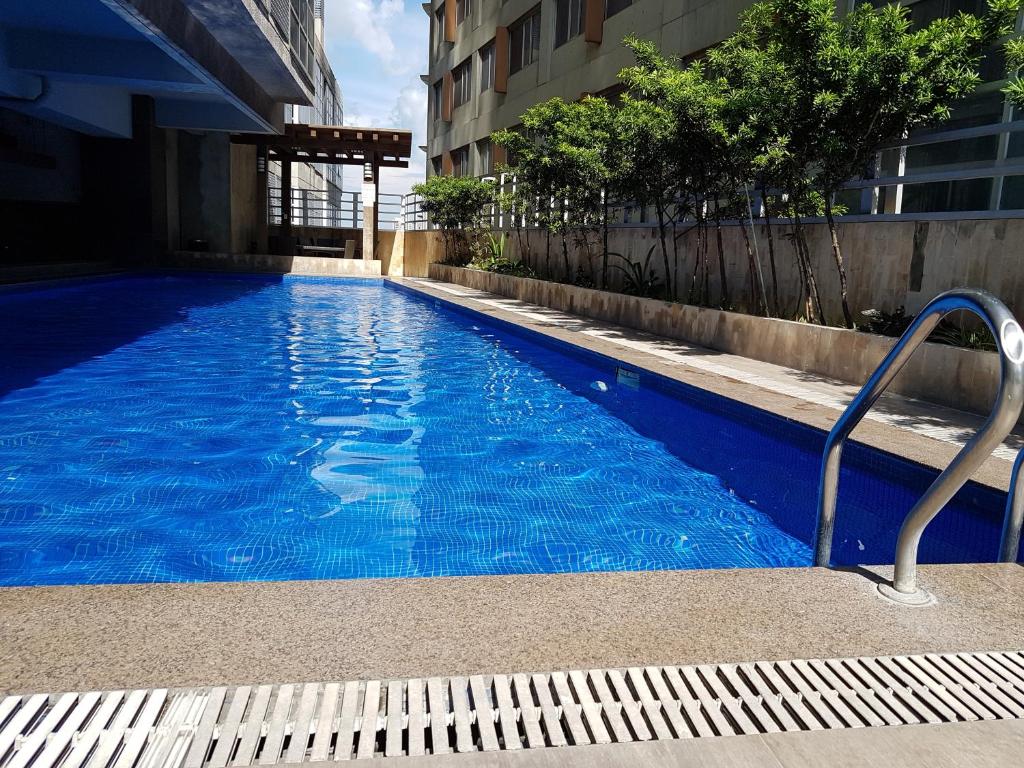 Luxury Budget Condo in Central Cebu في مدينة سيبو: مسبح ازرق كبير في مبنى