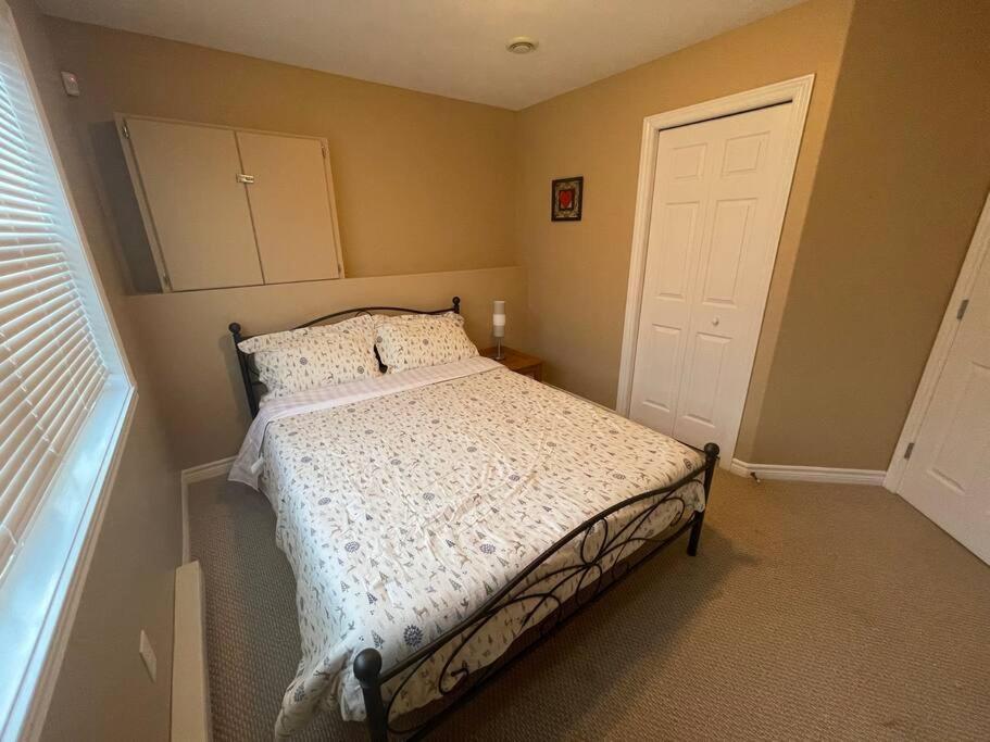 a bedroom with a bed with a white comforter at Armdale Urban Lodge, Dine & Stay in Halifax