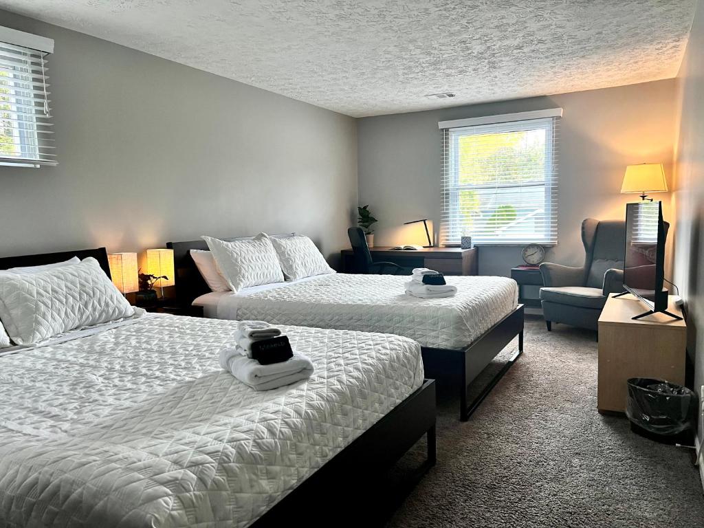a bedroom with two beds and a couch and a chair at Holly Oaks in Columbus