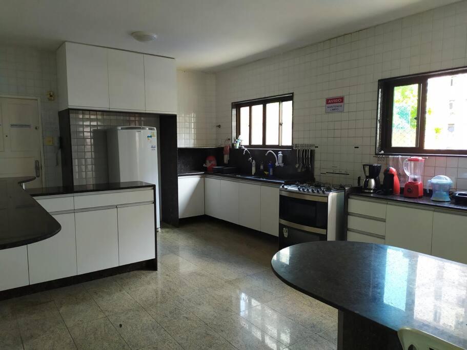 uma cozinha com armários brancos e um balcão preto em Ap. Cobertura Duplex Próx. Praia no Recife
