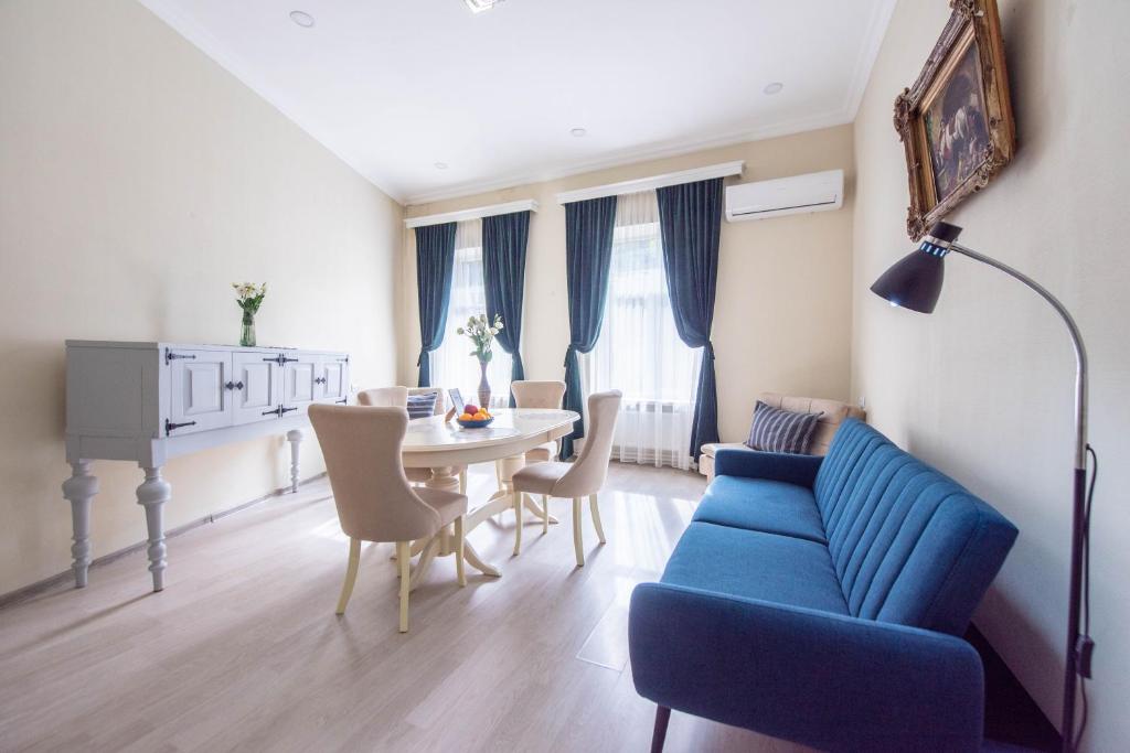 un soggiorno con divano blu e tavolo di Old Town-Booking Apartment a Tbilisi City