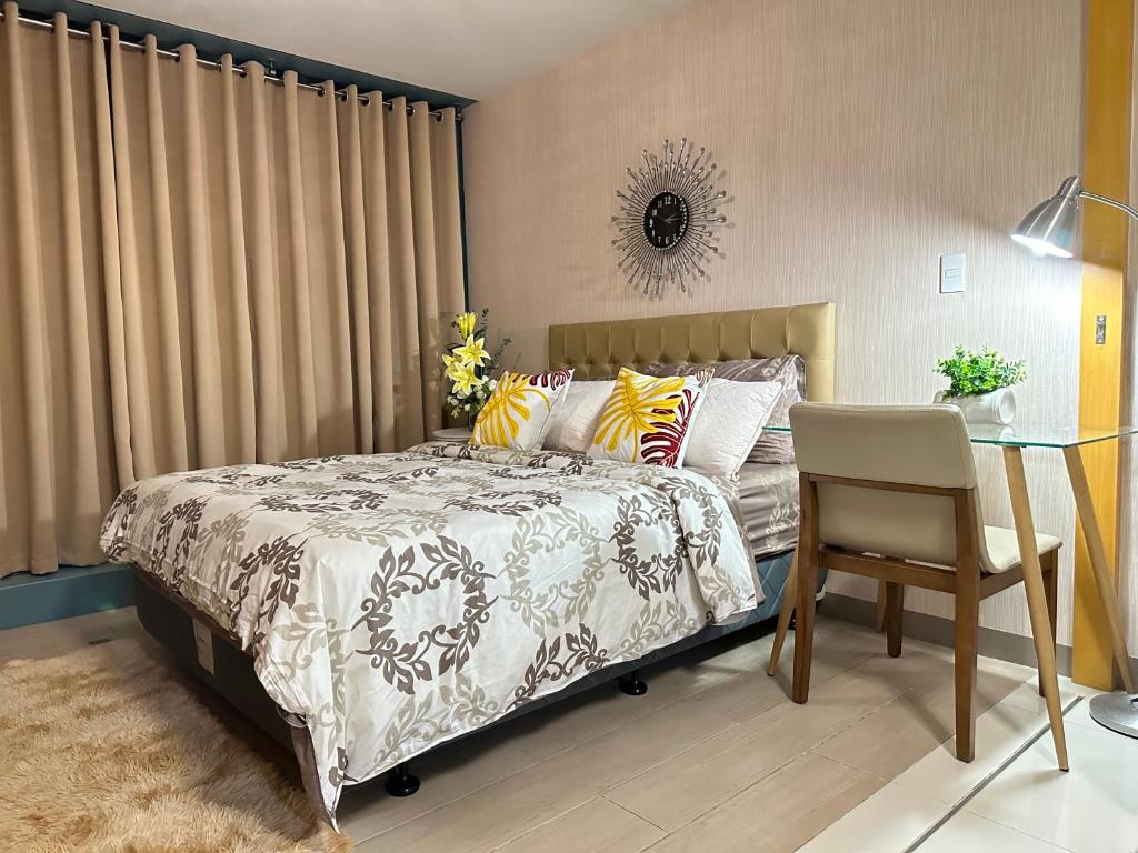 ein Schlafzimmer mit einem Bett, einem Tisch und einem Stuhl in der Unterkunft A Residence with a Mall and a Nightlife @Uptown, BGC in Manila