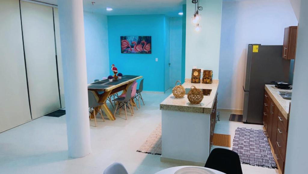 チクシュルーブにあるChicxulub Puerto Beach Penthouseの青い壁のキッチン(テーブル付)