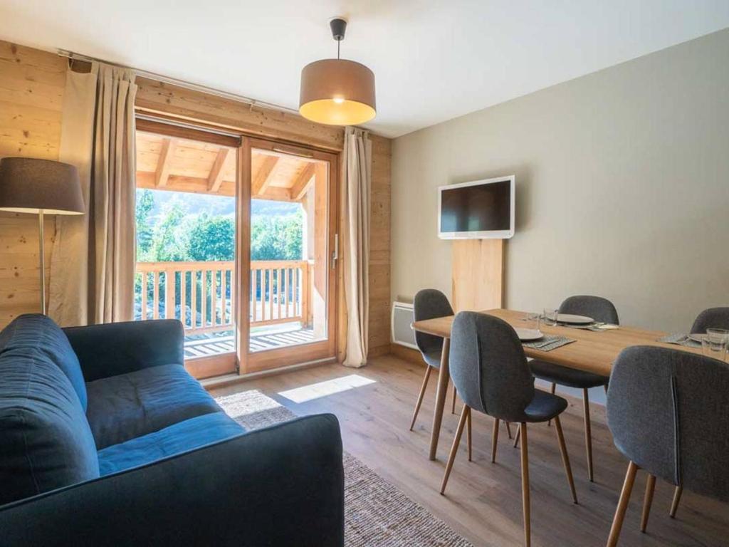 a living room with a couch and a table with chairs at Appartement Valmorel, 3 pièces, 6 personnes - FR-1-291-1003 in Valmorel