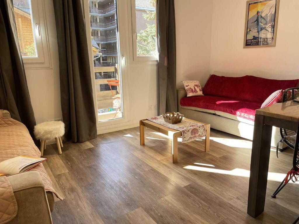 un soggiorno con divano rosso e tavolo di Appartement Risoul, 1 pièce, 5 personnes - FR-1-330-568 a Risoul