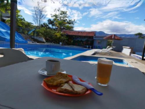 einen Teller mit Essen und ein Glas Bier auf dem Tisch in der Unterkunft Hosteria Cercaloma in Santa Isabel