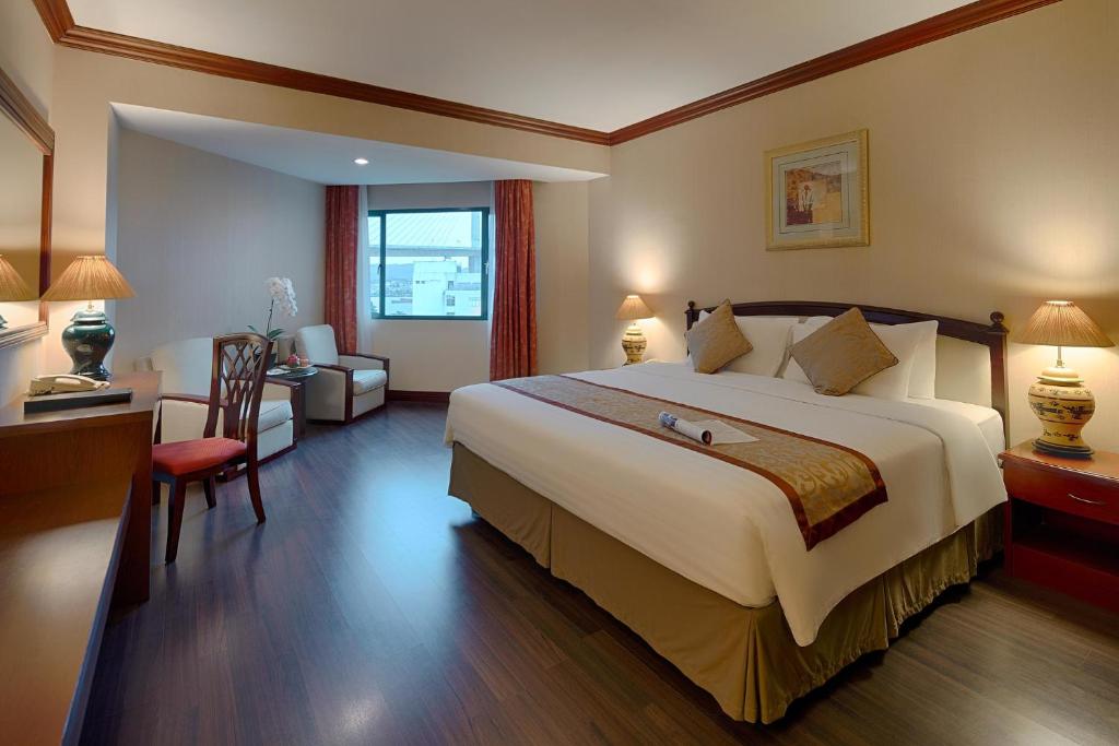a hotel room with a large bed and a desk at Halong Plaza Hotel in Ha Long