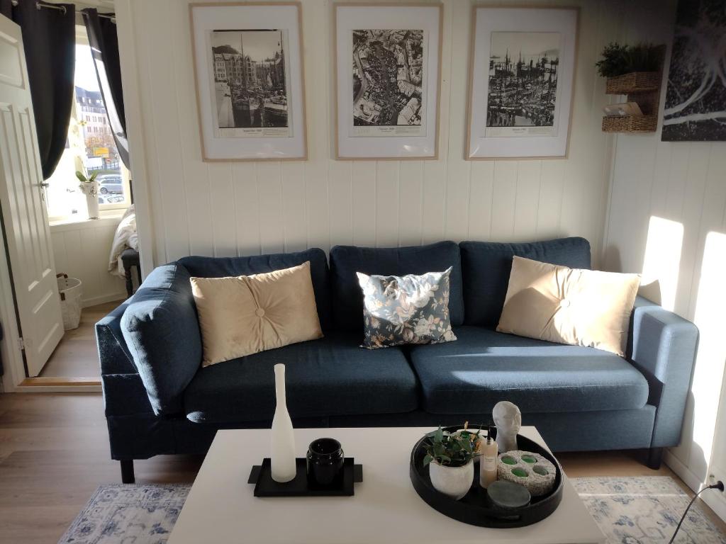 a blue couch in a living room with a table at Light home apartment Alesund with free parking in Ålesund