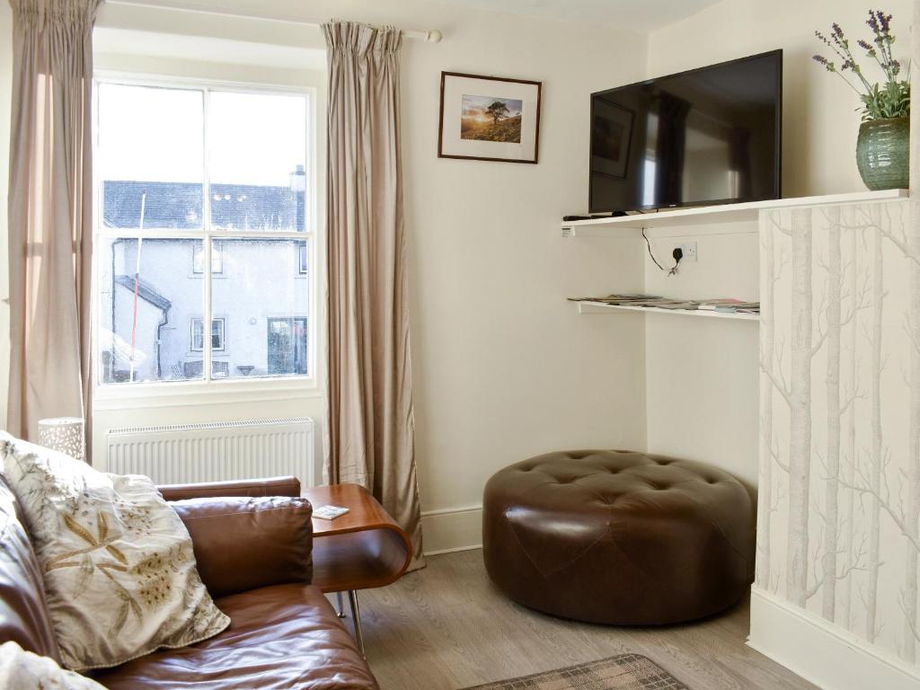 a living room with a couch and a chair and a window at Hunters Cottage - Uk44956 in Pooley Bridge