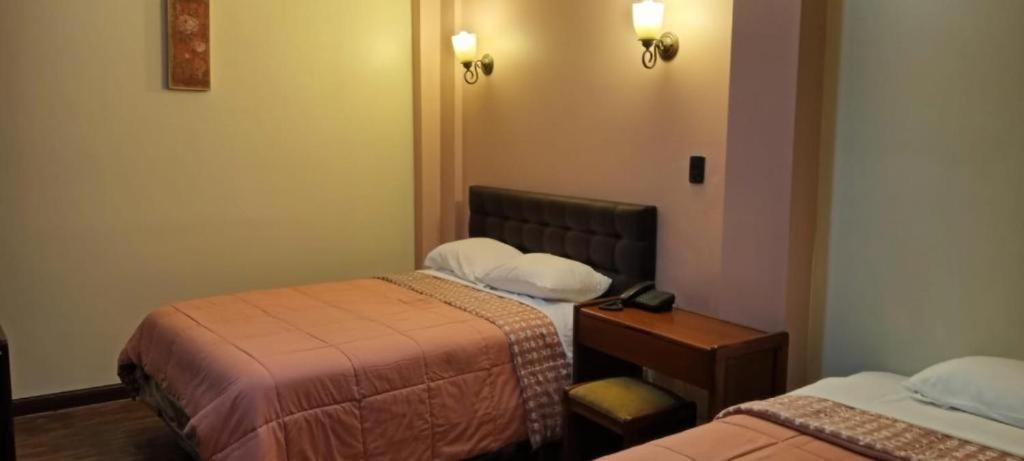 a hotel room with two beds and a night stand at JOMALEY in Loja
