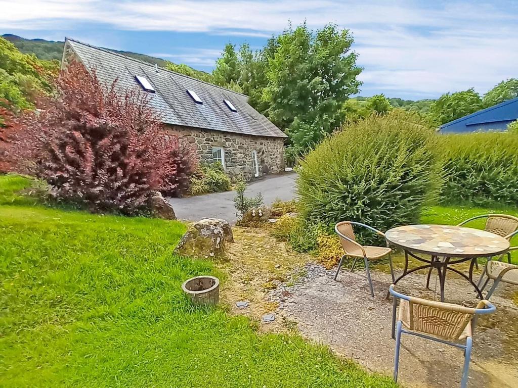 a garden with a table and chairs and a building at Arthfan in Llanelltyd