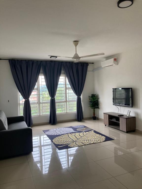 a living room with a couch and a tv at ABSYAR HOMESTAY SELASIH in Putrajaya