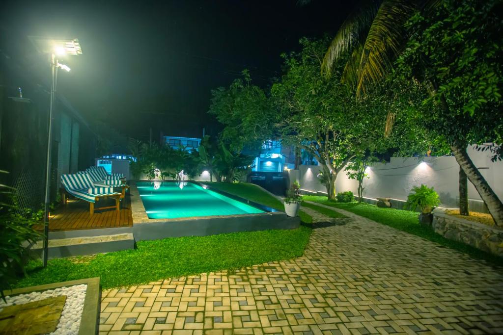 una piscina en un patio trasero por la noche en The Shades Galle en Galle