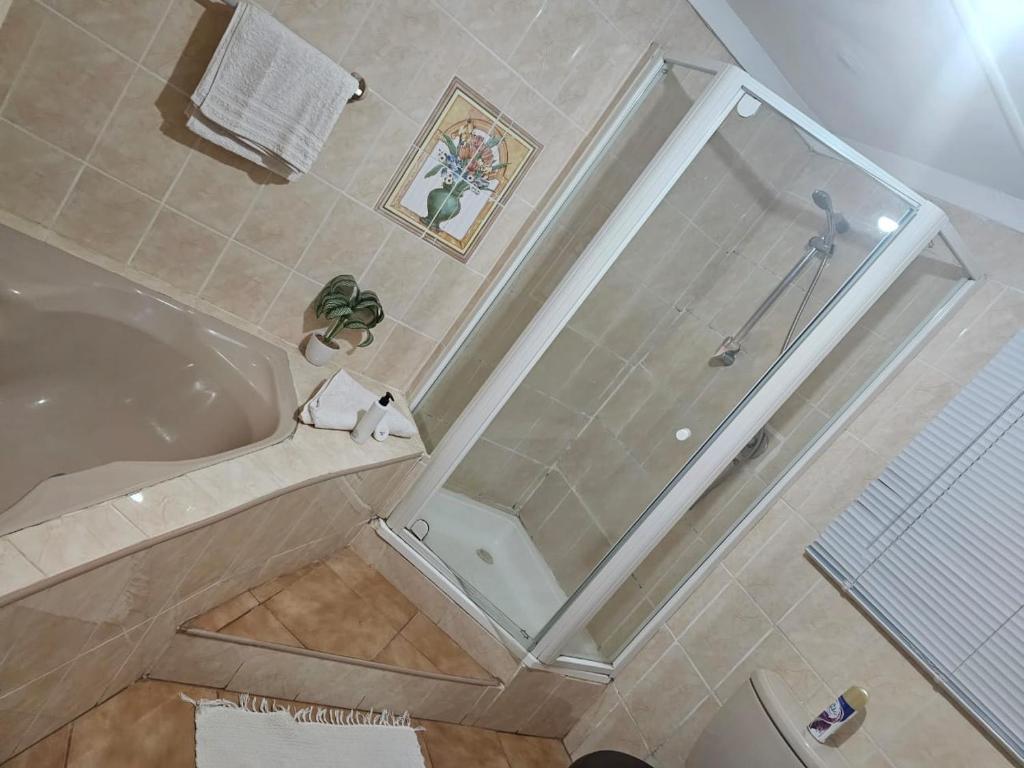 uma casa de banho com um chuveiro e uma banheira em Badi's B&B Guest house em Middledrift