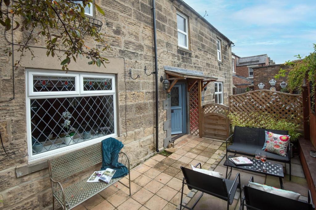 a patio with chairs and a table in front of a building at Owl Cottage in Morpeth