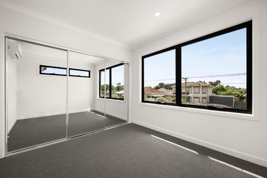 Brand new comfortable room in a beautiful suburb في St Albans: غرفة فارغة مع نافذتين كبيرتين في منزل