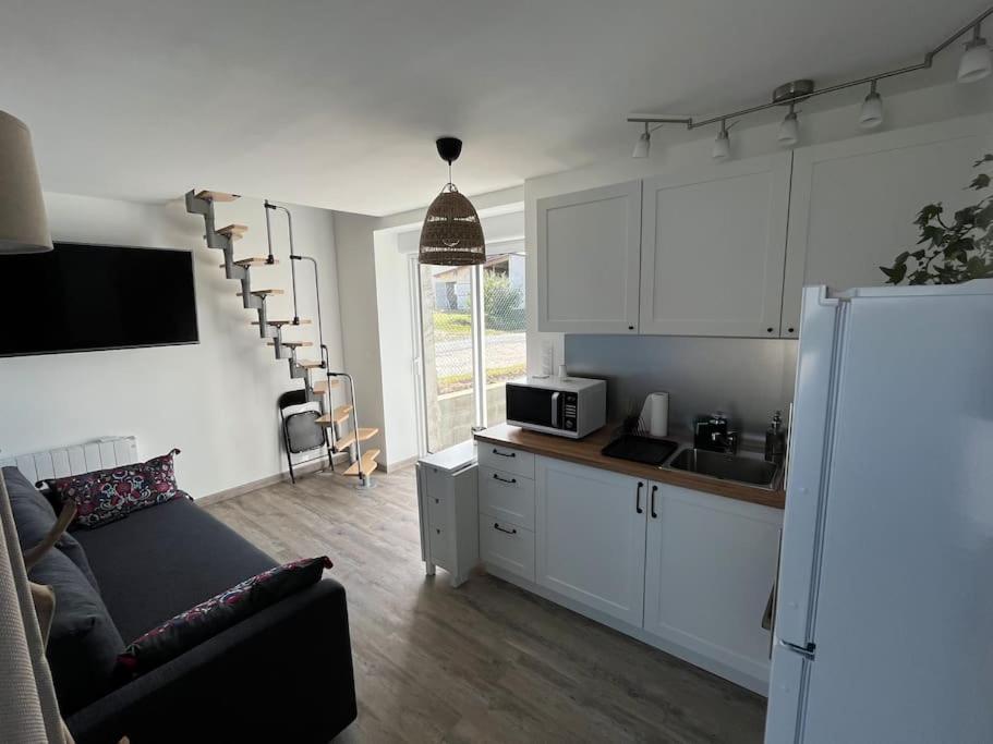 eine Küche und ein Wohnzimmer mit einem Sofa und einem Kühlschrank in der Unterkunft la halte des marais in Huismes