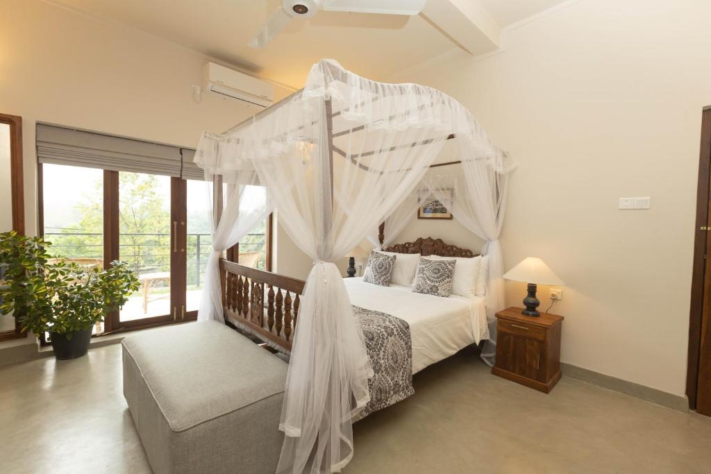 a bedroom with a canopy bed and a couch at Edgar Mansion Kandy in Kandy