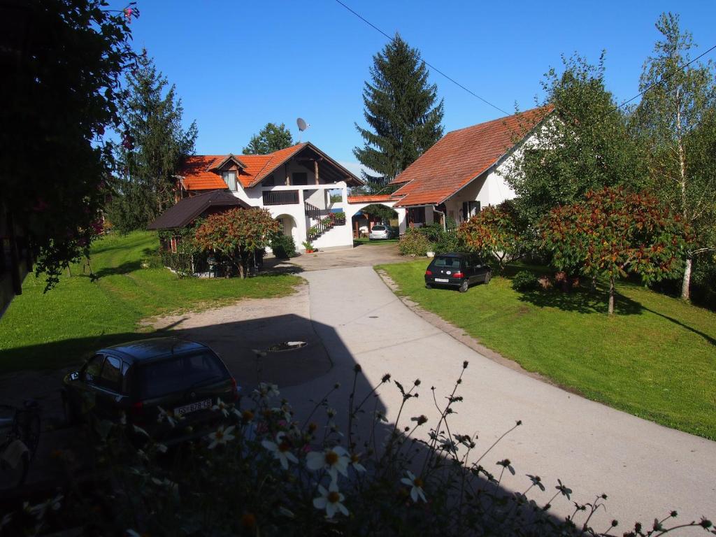 a house with a car parked in front of a driveway at House Ilija Hodak in Seliste Dreznicko