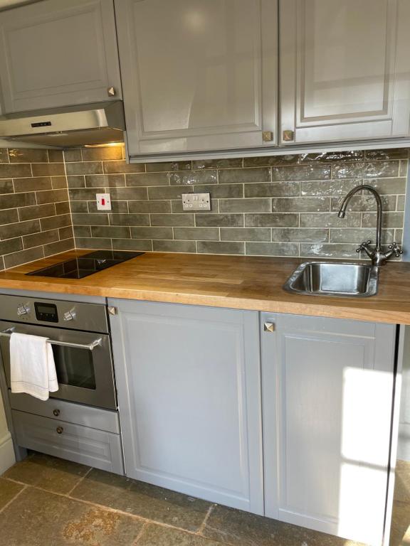 - une cuisine avec un évier et un comptoir dans l'établissement The Stable Loft. NEC, Airport, à Fillongley