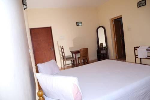 a bedroom with a bed and a table and chairs at Mimosha Holiday Inn in Rambukkana