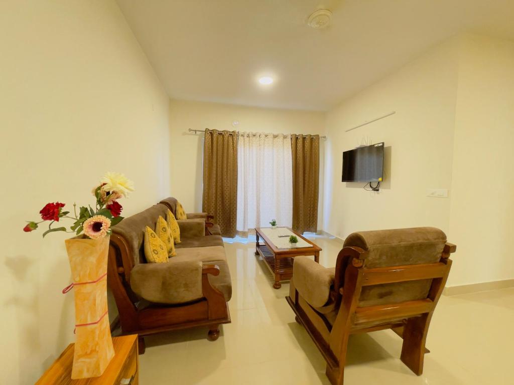 sala de estar con sofá, sillas y TV en ALanKrita Homes en Lucknow