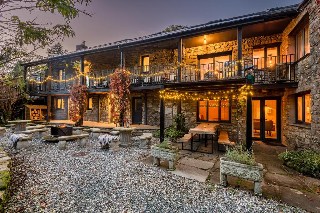 ein großes Backsteinhaus mit einer Terrasse mit Bänken in der Unterkunft The Waterfall Retreat in Penrith