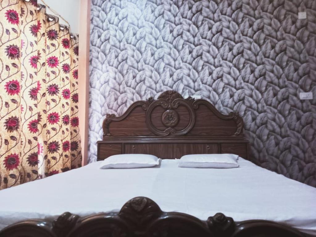 ein Holzbett mit zwei Kissen darüber in der Unterkunft RN Residency in Varanasi