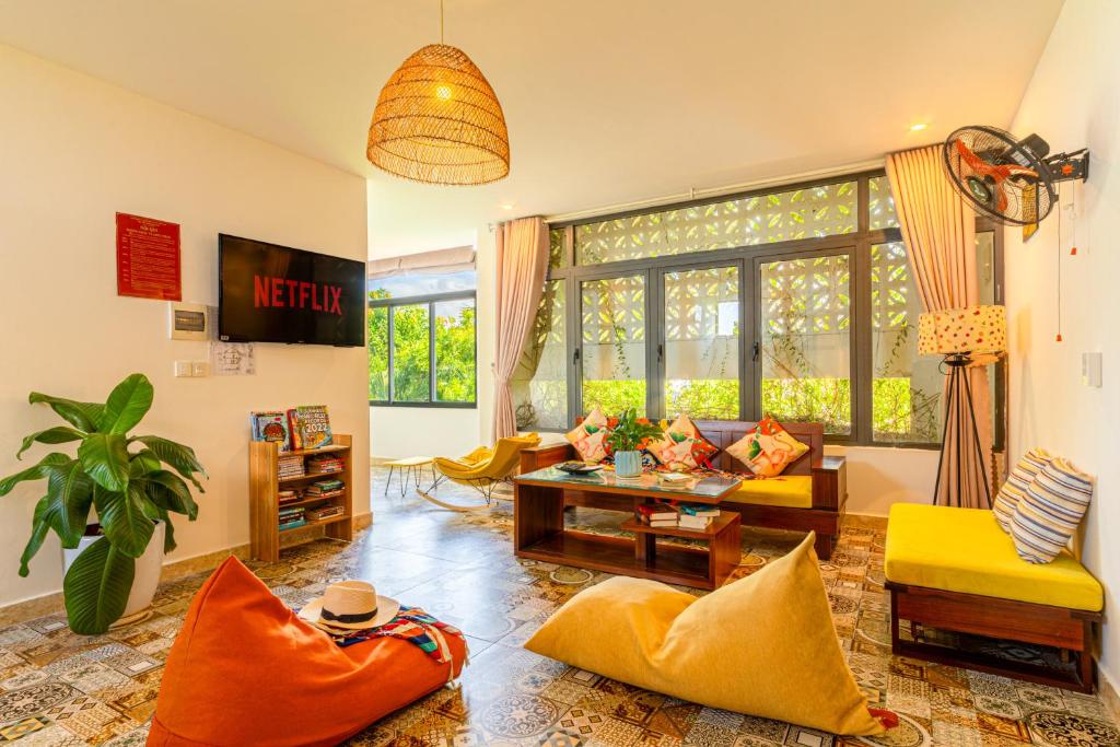 a living room with a couch and a table at HA Gateway Inn Hoian Pool Villa in Hoi An