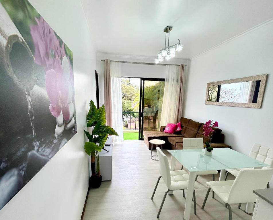a living room with a table and a couch at Santa Catarina by Olá Madeira in Funchal