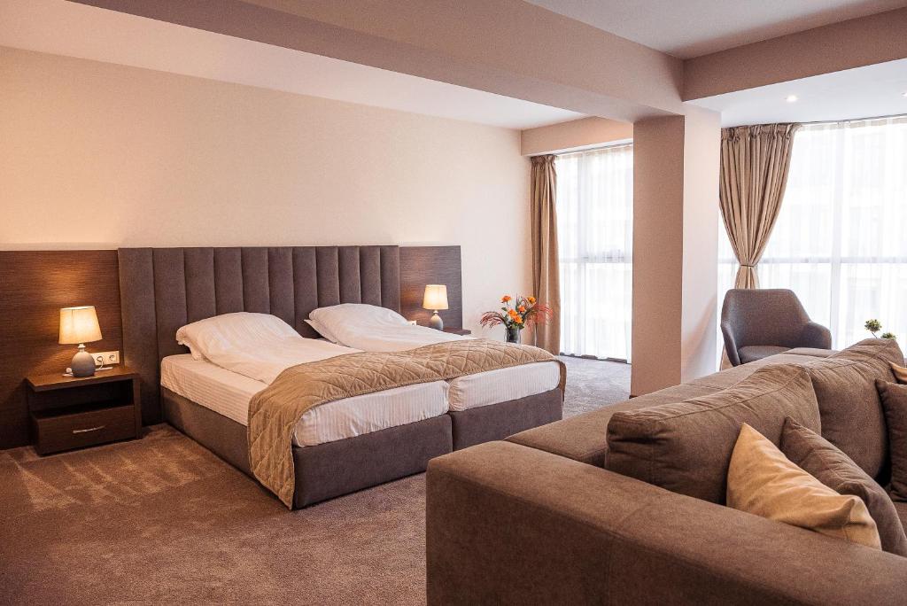 una camera con un grande letto e un divano di Cityscape Luxury Suites a Plovdiv