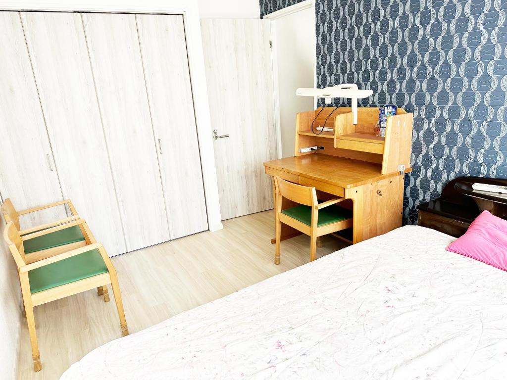 Schlafzimmer mit einem Schreibtisch, einem Bett und einem Schreibtisch in der Unterkunft 花乃郷 本郷 in Tokio