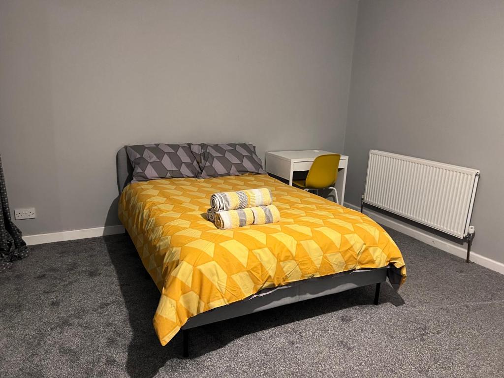 a bedroom with a bed with a yellow comforter at Modern Double Room With Free Parking & Fast WiFi 5 Mins To Warwick Uni in Canley