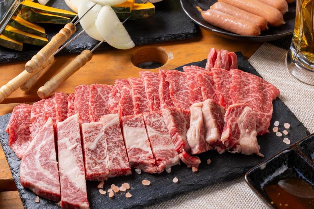 un montón de carne en una tabla de cortar en una mesa en Glamchette Okayama -Glamping & Auto Camp- - Vacation STAY 44593v, en Mimasaka