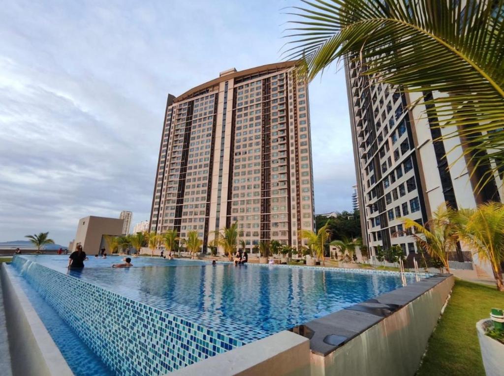 a large swimming pool in front of a tall building at Botiza Suites at Jesselton Quay in Kota Kinabalu