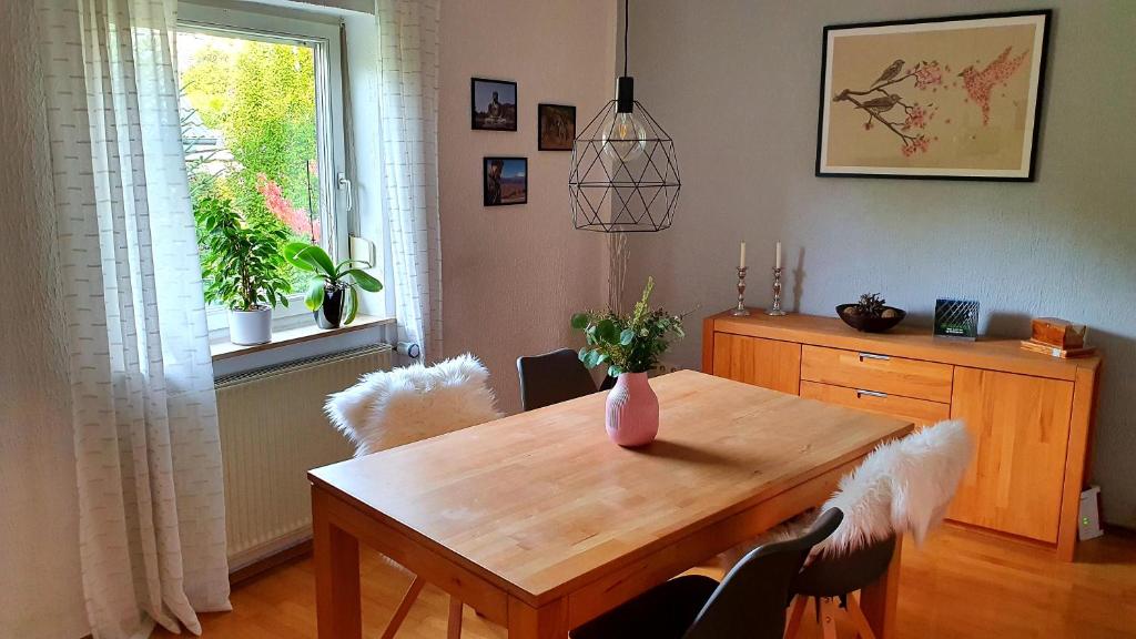 comedor con mesa de madera y ventana en Zweite Heimat Bamberg, en Stegaurach