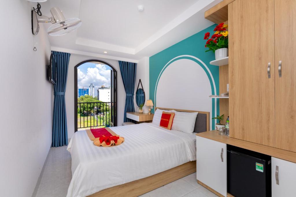 a bedroom with a white bed and a window at Gold Holiday Hotel in Vung Tau