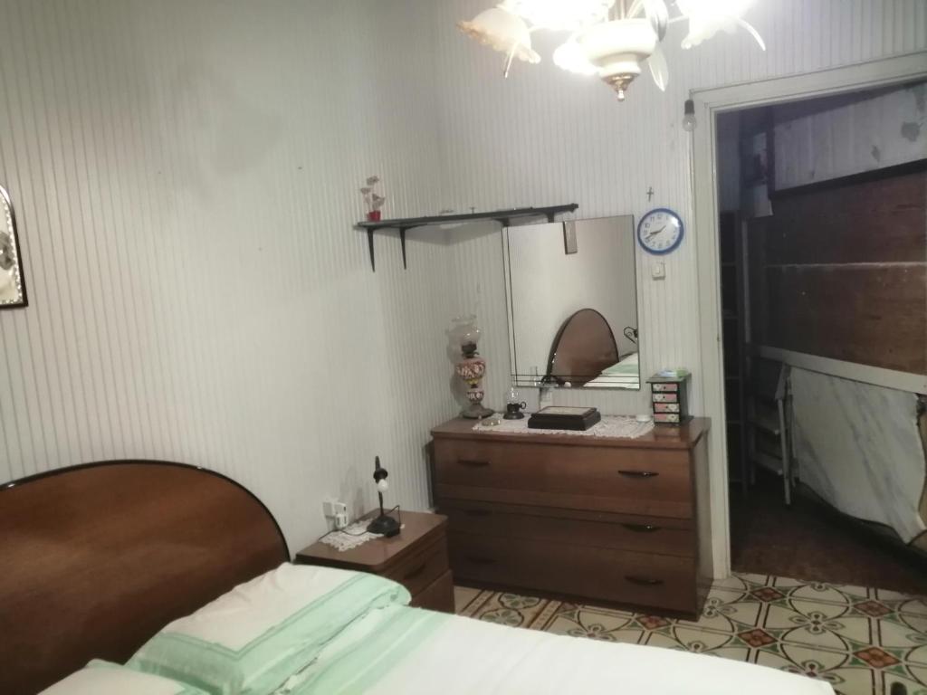 1 dormitorio con cama, tocador y espejo en Appartamento con una camera matrimoniale, bagno in camera cucina e veranda esterni, en Rilievo