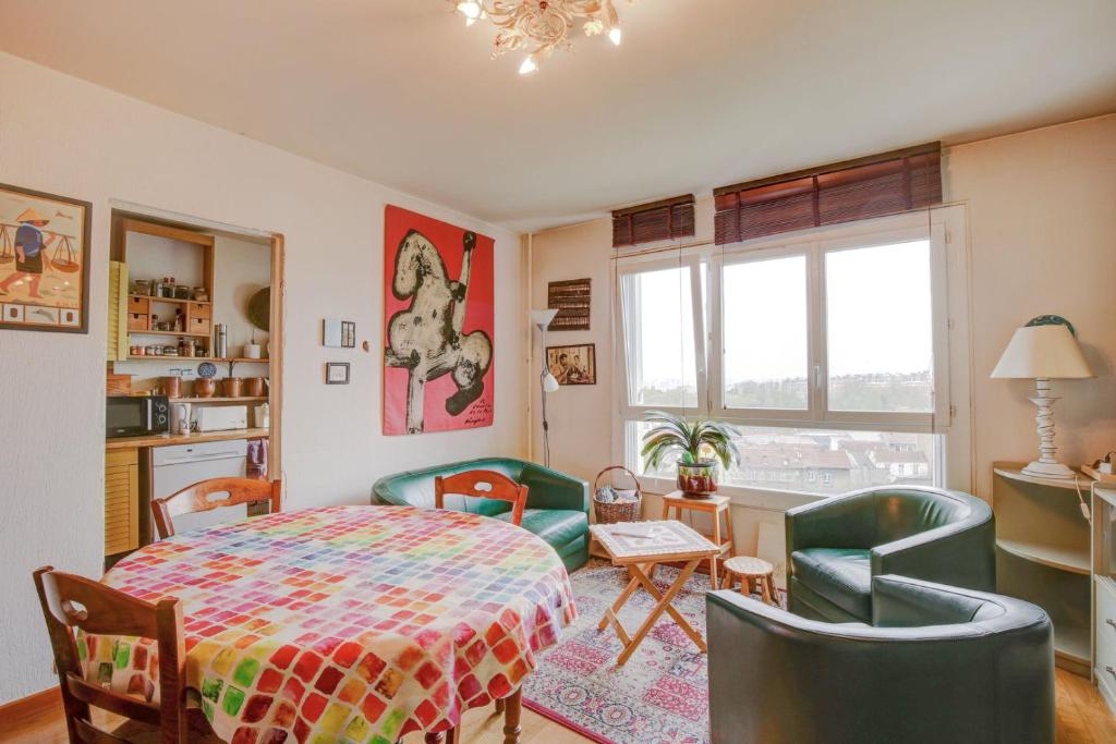 une chambre avec un lit, une table et des chaises dans l'établissement Aux Portes des Lilas, à Bagnolet