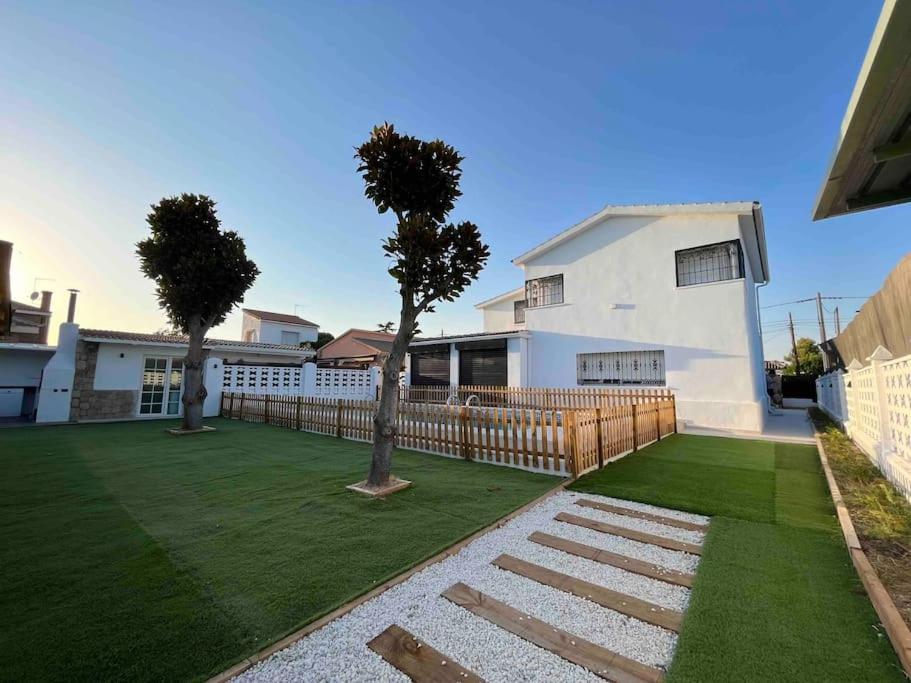a house with a yard with a fence and trees at Villa Jiménez in Griñón