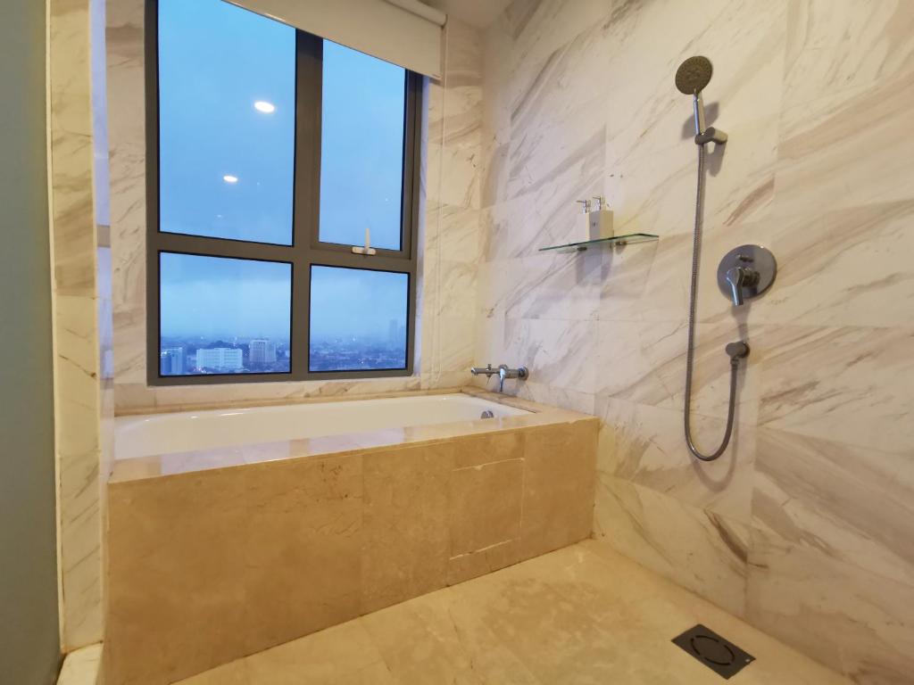 uma casa de banho com uma banheira e uma janela em Attic Home Melaka Silverscape Residence & Jonker em Malaca