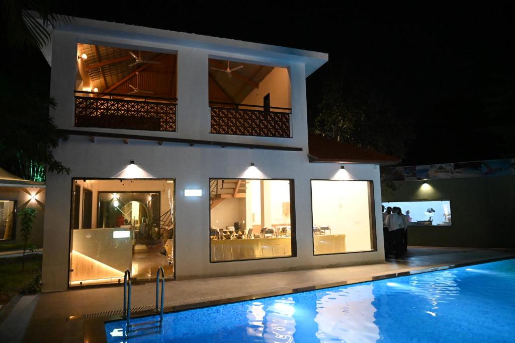 a house with a swimming pool at night at The Whispering Palms Resort in Bhopal