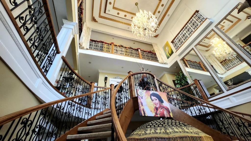 a spiral staircase in a house with a picture of a woman at Empress Palace Hotel in Surrey